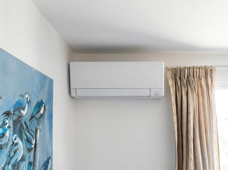 Intérieur résidentiel épuré, climatiseur mural monté en hauteur sur mur blanc
