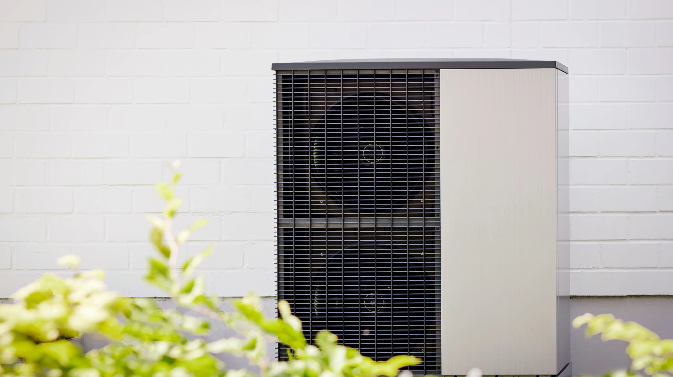 Technicien HVAC en uniforme vert travaillant sur système de chauffage/climatisation dans intérieur résidentiel