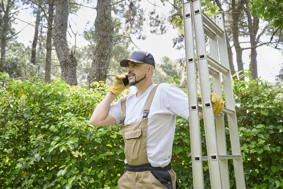 Technicien en climatisation travaillant à l'extérieur sur une pompe à chaleur ou climatiseur résidentiel