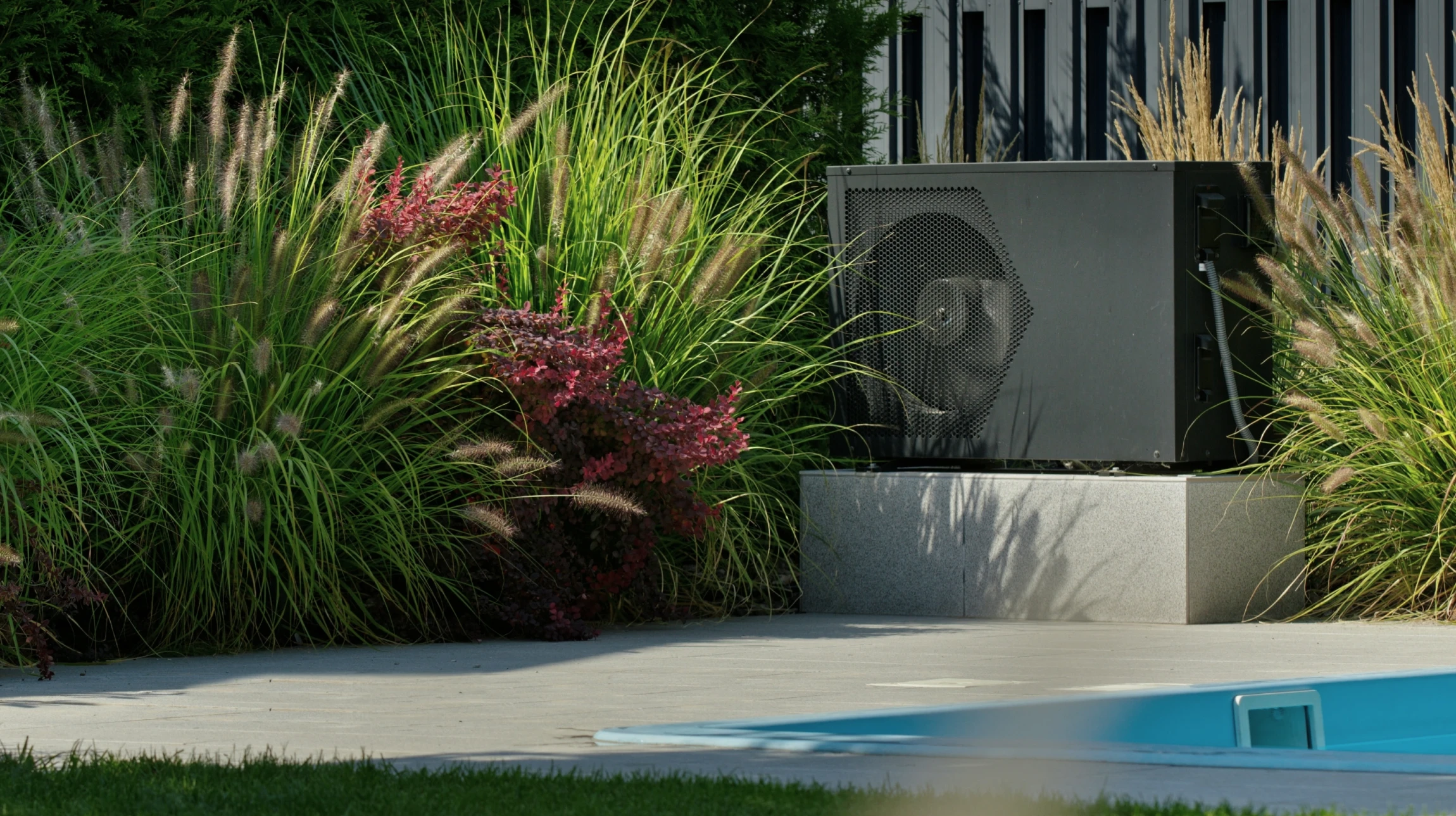 Pompe à chaleur près d'une piscine avec verdure décorative